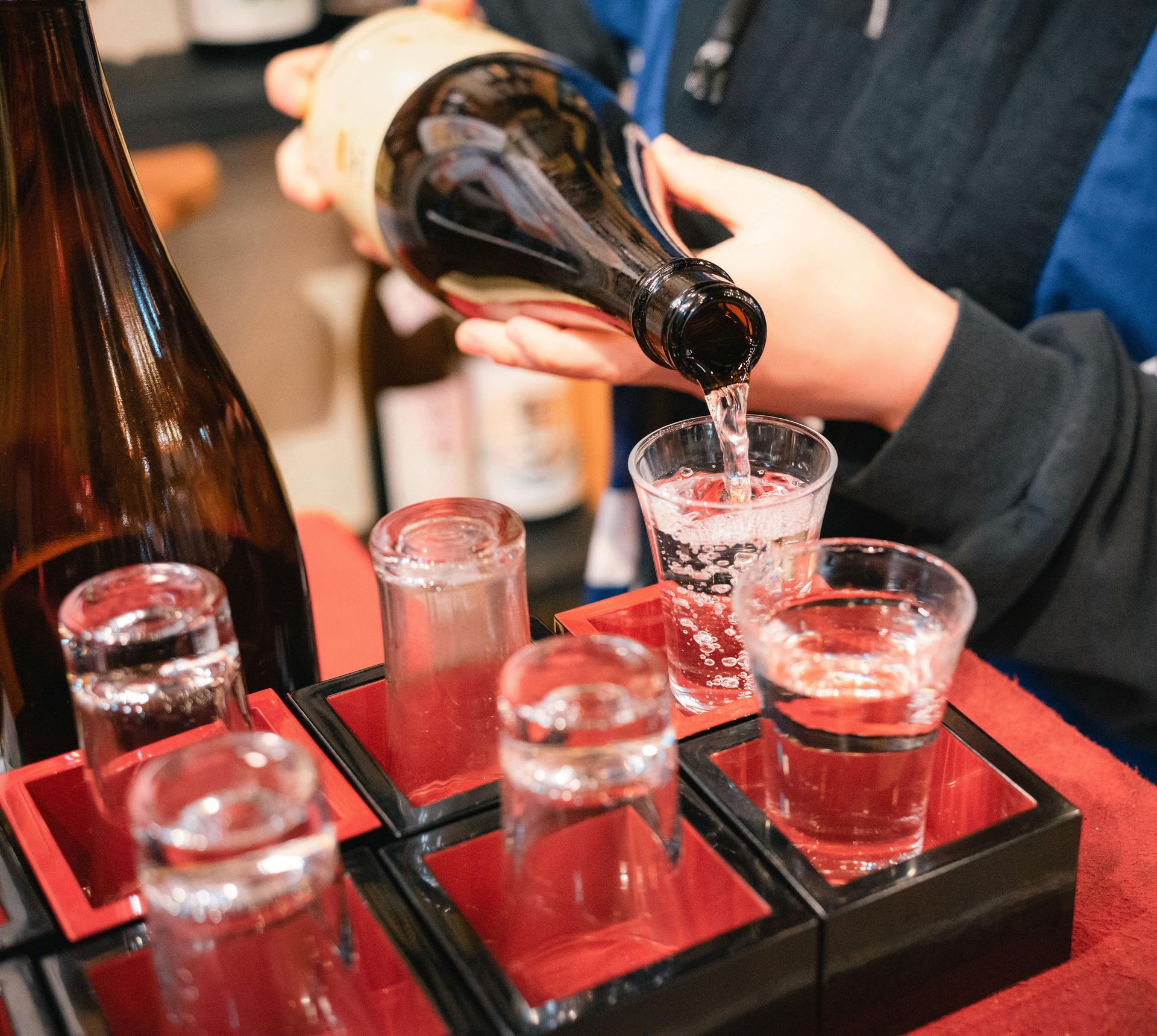 Pouring Sake at a Traditional Japanese Stall